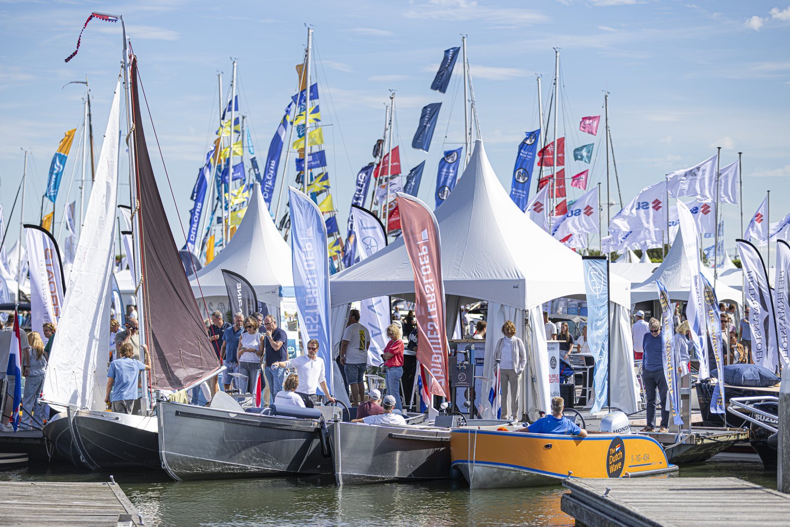 Sloepen aan de steiger tussen de vlaggen van exposanten op HISWA te Water 2026